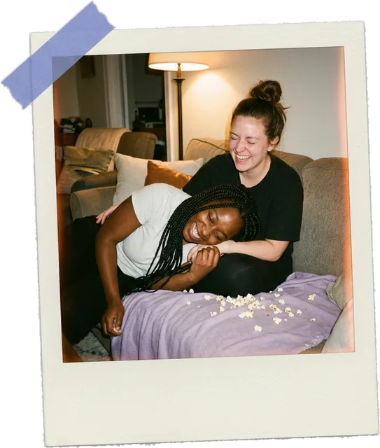 Polaroid photo of a couple laughing on the couch with popcorn